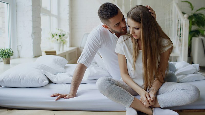 Upset woman being comforted by her partner.