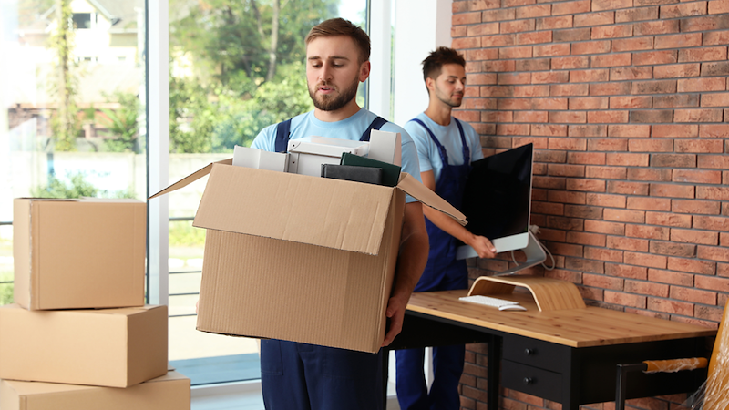 People moving boxes out of an office.