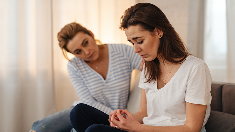 Woman comforts her crying friend. 