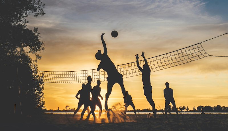 A team playing volleyball together. Still frame for contextual reference only.
