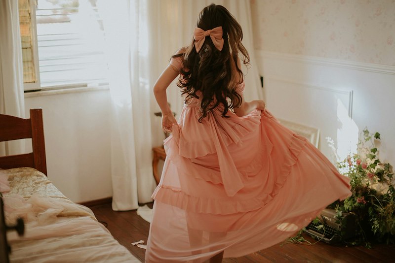 Woman wearing a flowing peach-colored dress.