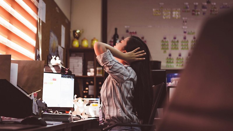 An overworked employee sits at her desk
