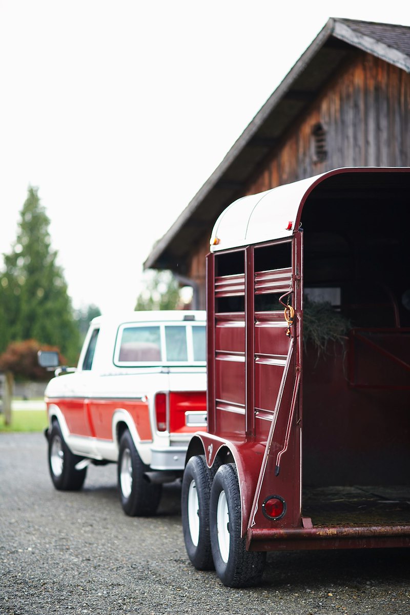 Red pickup truck towing a large trailer.