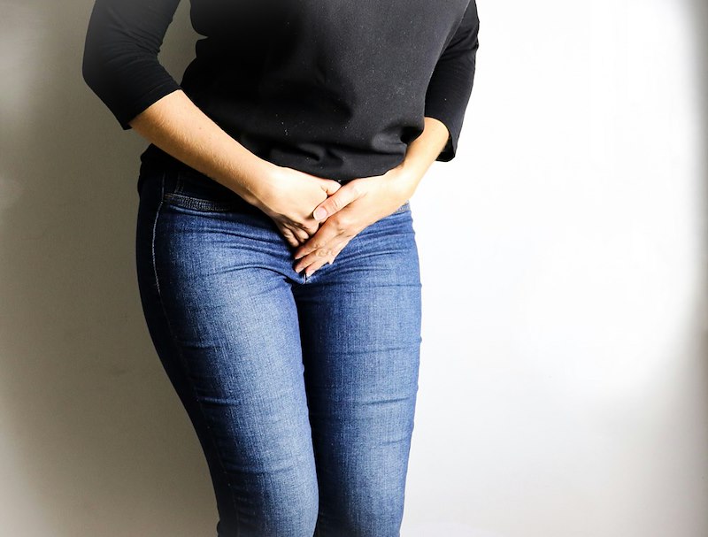 Woman holding her stomach in discomfort.