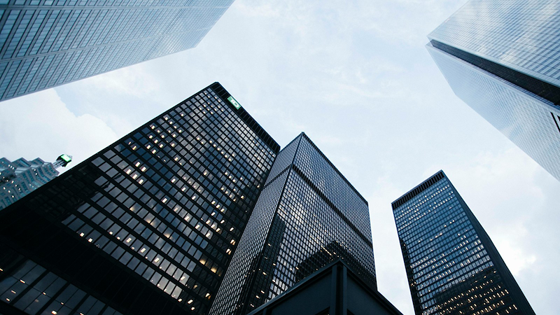 High-rise corporate buildings as viewed from the ground.