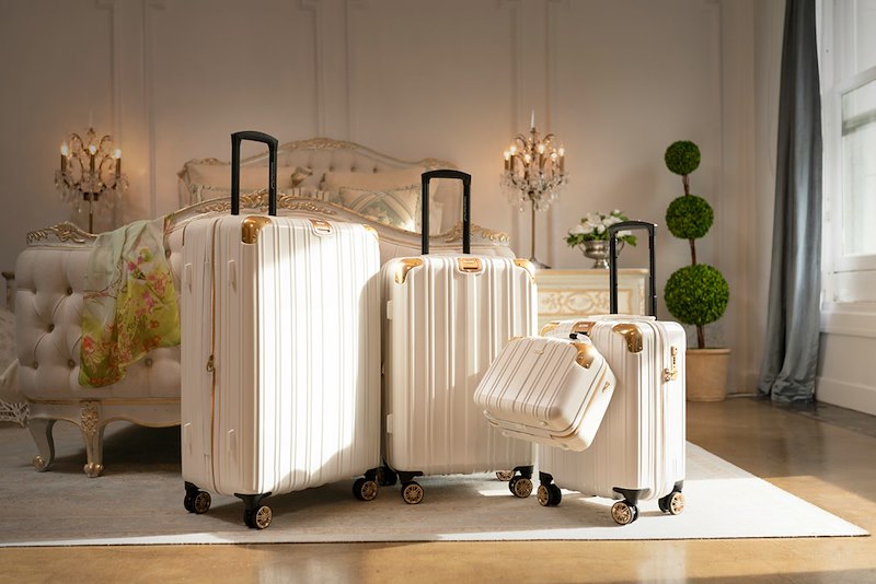 Three pieces of white luggage sitting in a room.