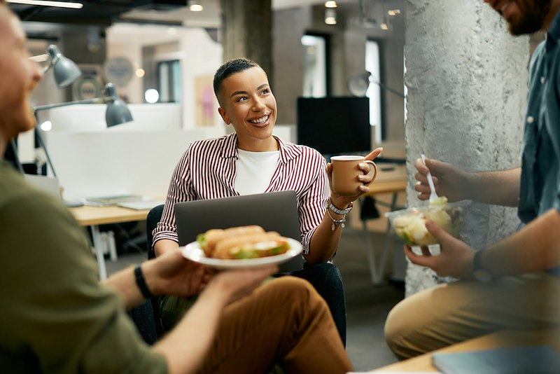 A group of employees sit around eating lunch