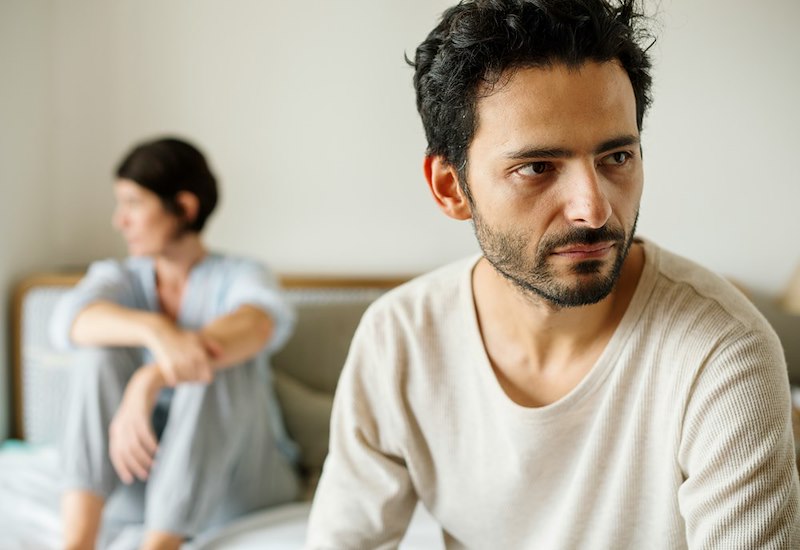 A married couple argue on a couch