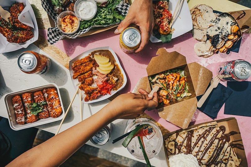 A group of people sitting around a table eating the food they ordered.