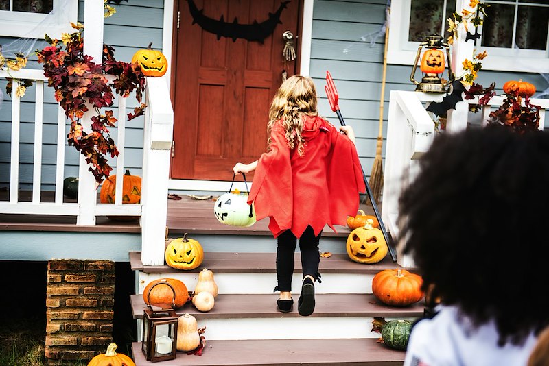 A child goes up to a house on Halloween to trick or treat