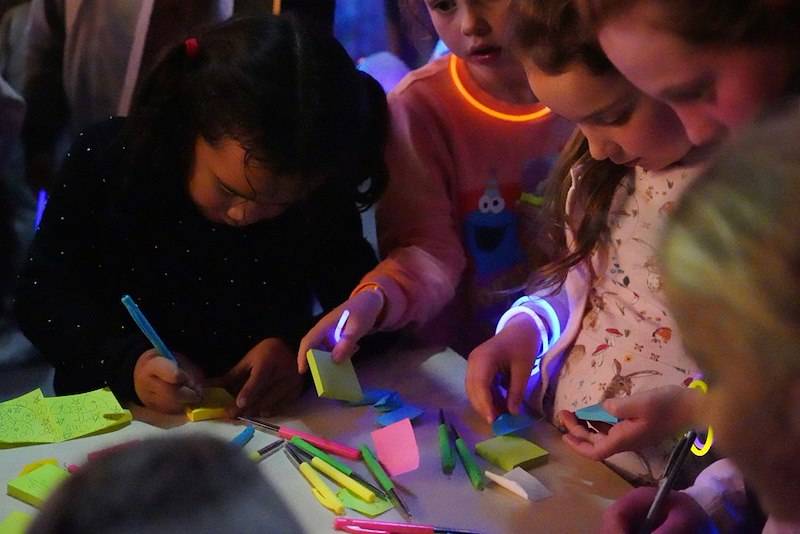 A group of kids play with craft materials at a party