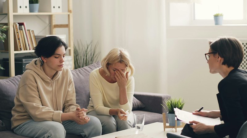 A mother and a child together at a therapy session. Recreated scenario included to enhance reader understanding.