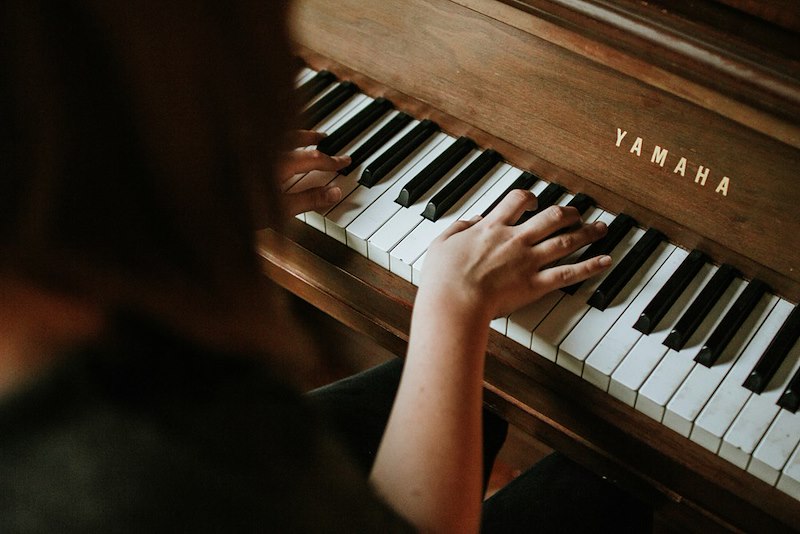 A person playing a big piano. Scene shown is a visual representation.