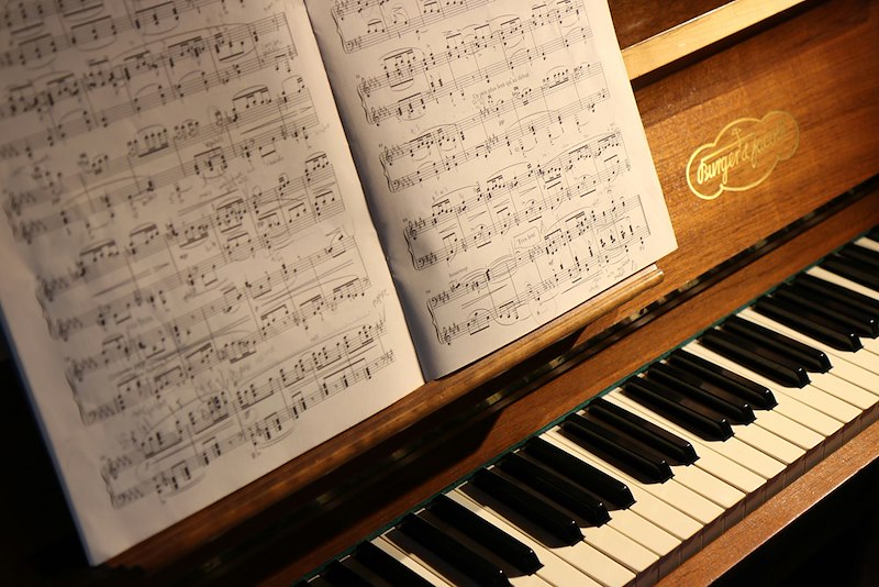 A music sheet on a brown piano.