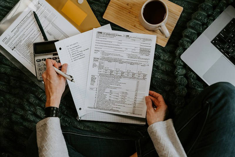 A person analyzing financial data in documents. Not actual story subjects.