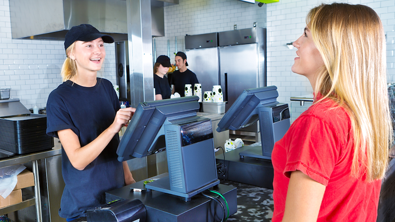 Employee getting costumer's order at fast food restaurant