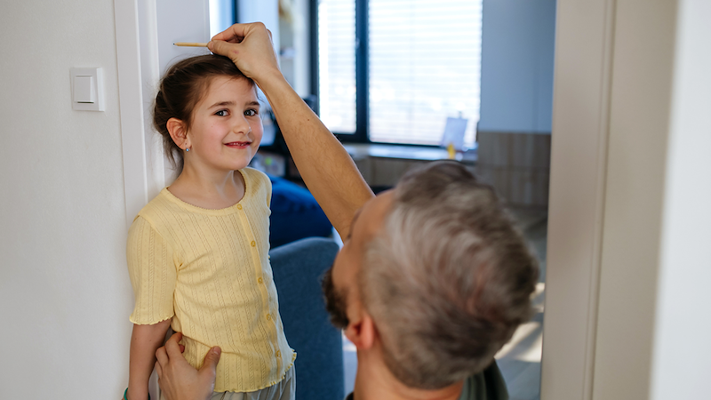 Father Measuring His Daughter's Height at Home