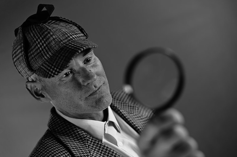 A private investigator in stereotypical attire
