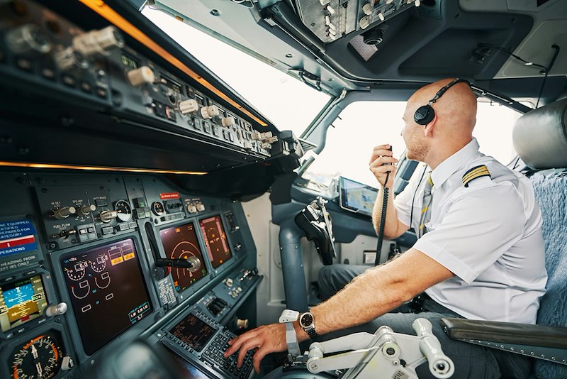 A pilot sits in the cockpit of a plane