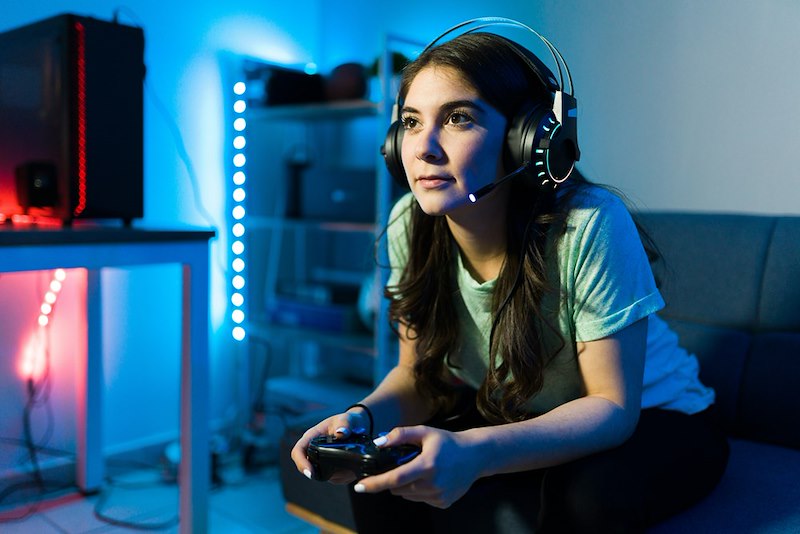 A video game tester stares intently at the screen of the game she is playing.