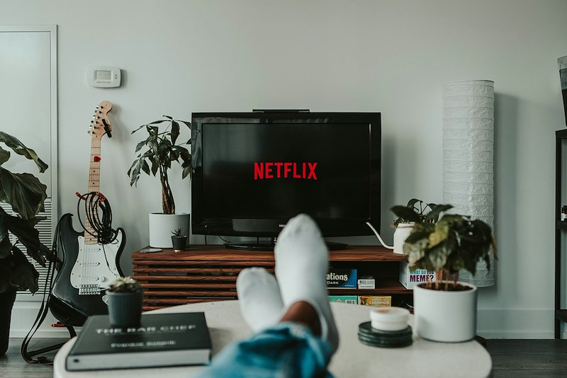 A person watching TV on the couch.