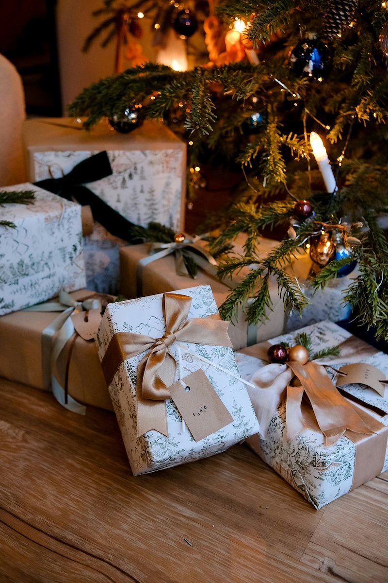 Wrapped presents beneath a Christmas tree, representing the gift a sister decides not to buy for her older brother.