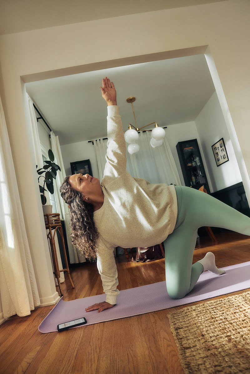 A yoga instructor practicing poses in her apartment living room.