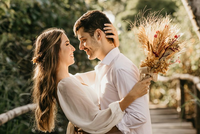 An engaged couple posing for a romantic photo in a public park in New England.