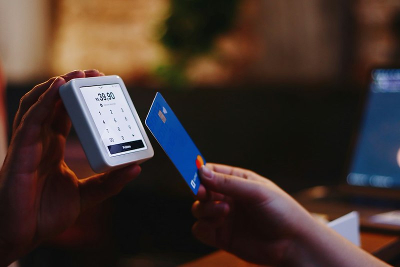 A person uses tap to pay on their device with their credit card