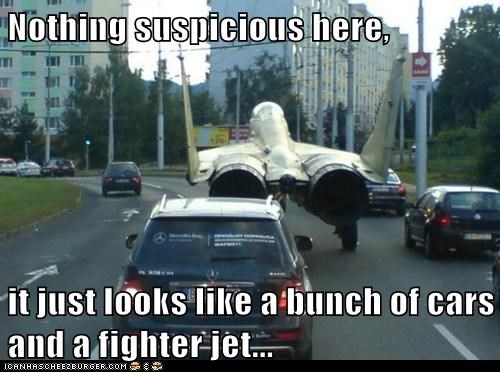 Nothing suspicious here,  it just looks like a bunch of cars and a fighter jet...