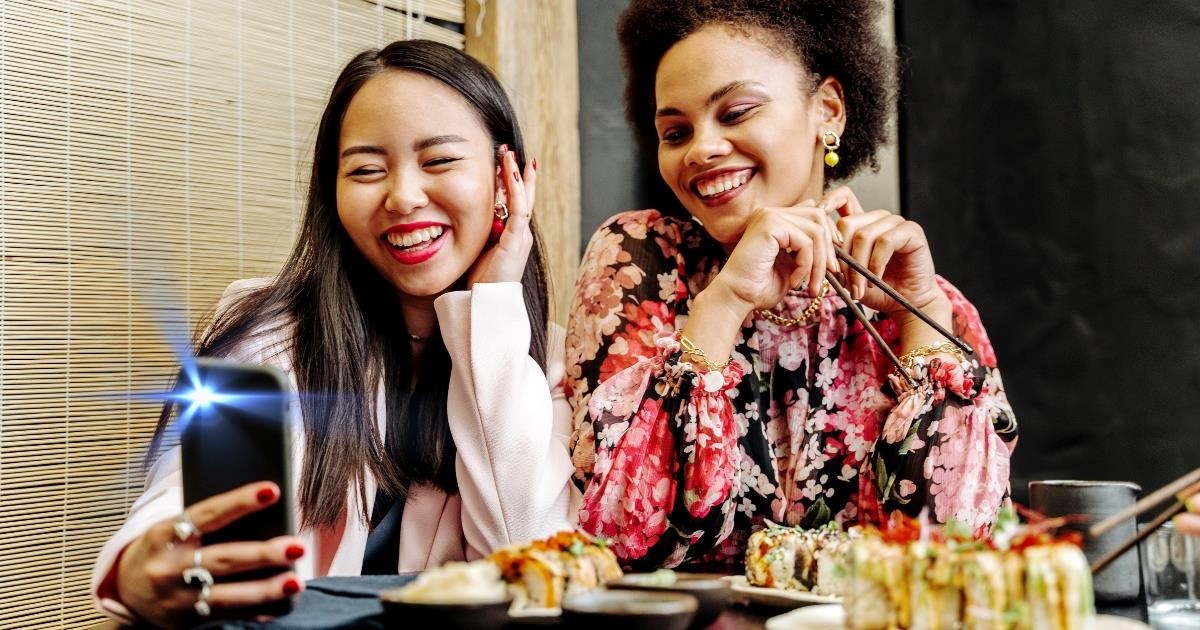 Two women are repeatedly blinded by a nearby group’s camera flash as they take multiple videos at a late-night sushi spot, ignoring the women's polite requests to stop filming, the group goes on to mock them further: 'The flash shining at us'