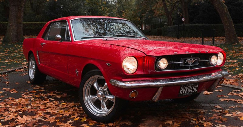 1965 Mustang parked outside on top of leaves on the sidwalk
