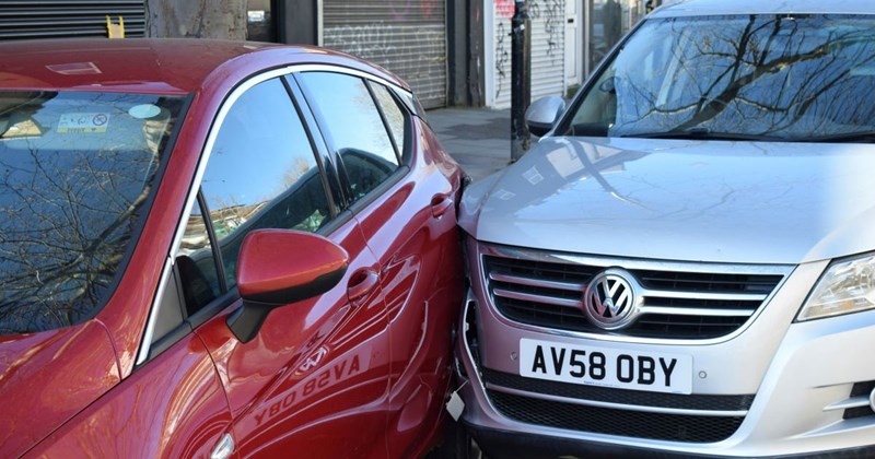 A silver car hitting a red car from the back