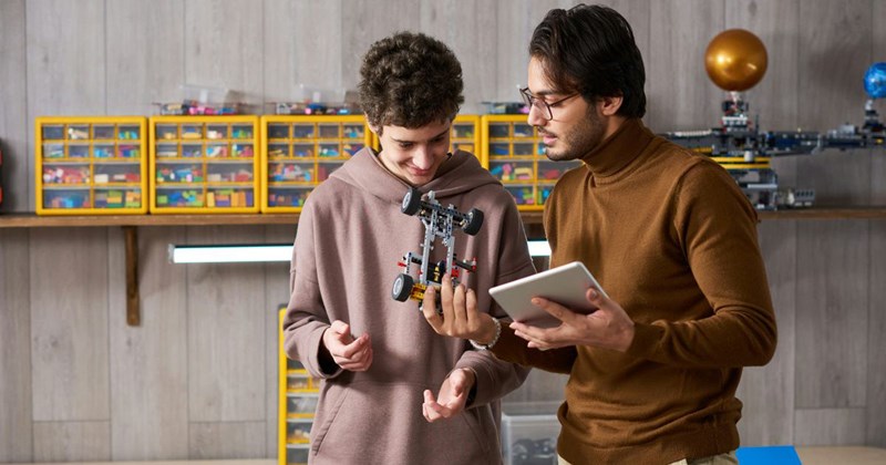A nephew and uncle look at Lego car together