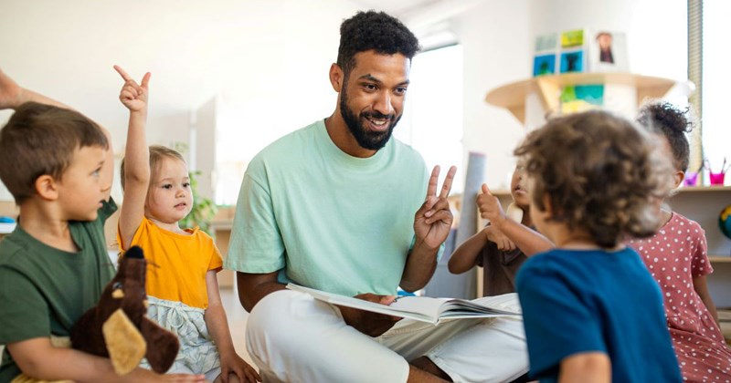 Male daycare teacher works with students