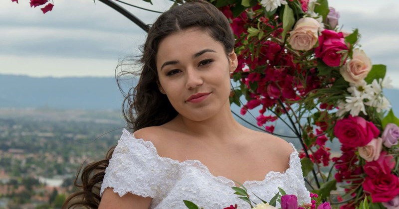 Young bride looks at the camera and smiles, content that she didn't invite her cousin to her wedding