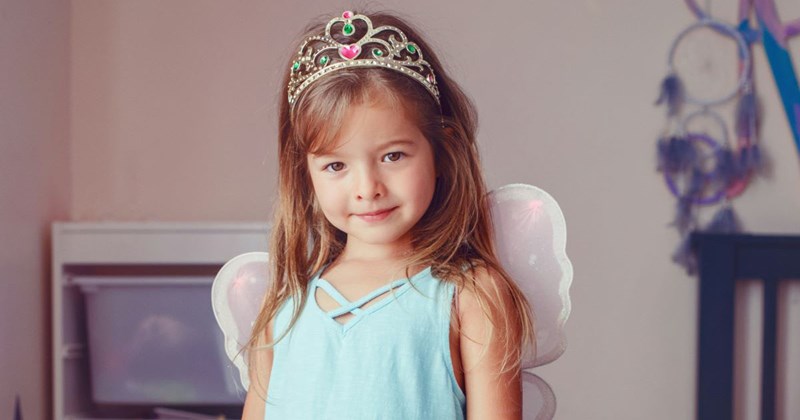 Little girl stands in her bedroom dressed as a fairy princess
