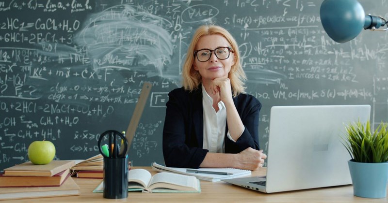 A substitute teacher sits at her desk
