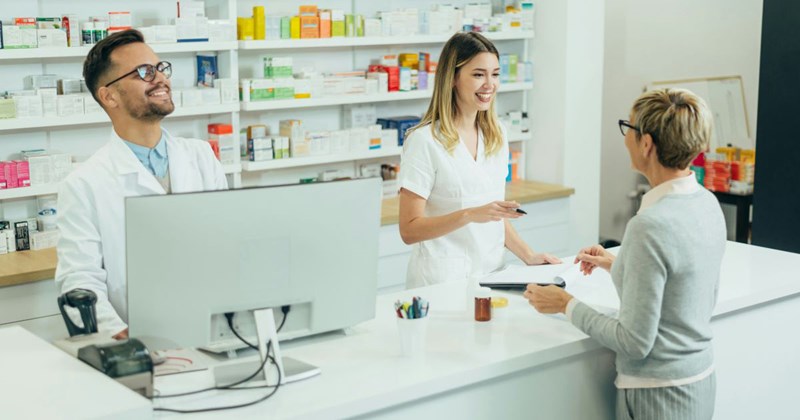 Two pharmacists, the only pharmacists employed at this pharmacy, work together at the counter
