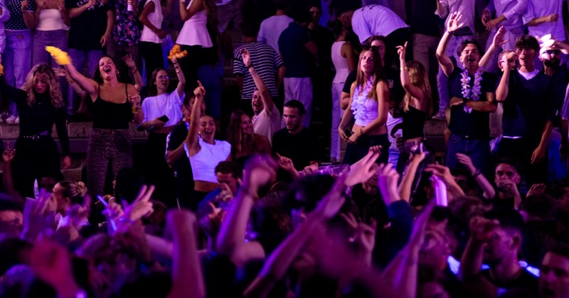 Numerous people dance in the crowd at a concert