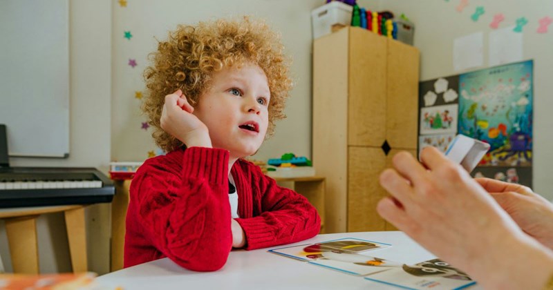 A little boy learns how to pronounce words with the help of a speech therapist. 