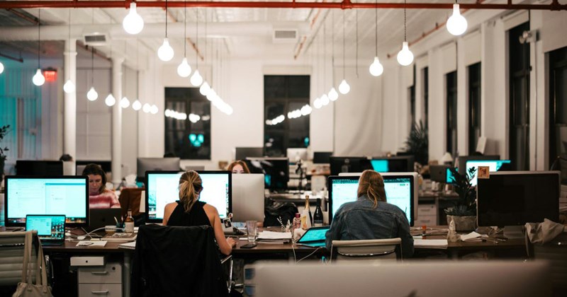 Employees from different companies work side by side in a coworking space.