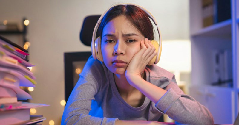 A Gen Z employee pouts at her desk, unconcerned with what her boss thinks about her attitude.