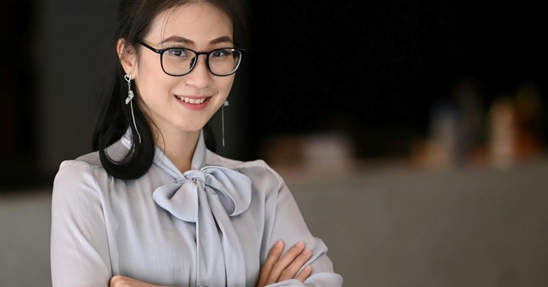 A young female employee crosses her arms and smiles
