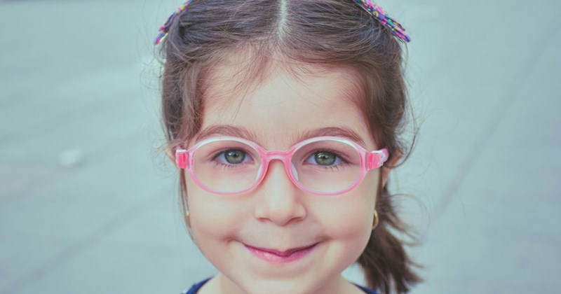 An adorable little girl wears her glasses before a nefarious Karen tells her she looks better without them.