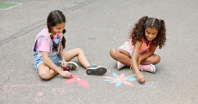Two little girls representing the girls in this story, who have repeatedly been left home alone by their mother, are playing outside without anyone supervising them at an extremely young age. 