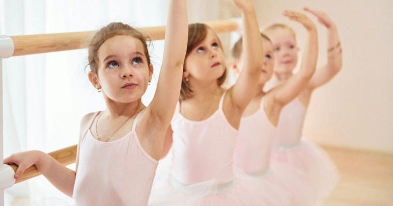 Young ballerinas preparing for a dance recital for their family and friends