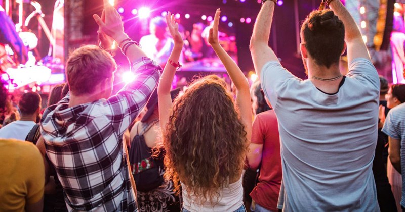 Tall concertgoers, who may be blocking the view of the concert for shorter viewers behind them.