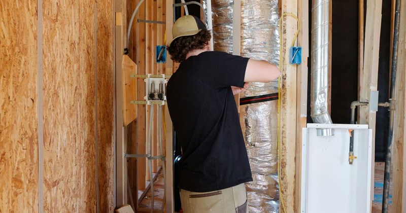 An HVAC worker makes repairs in the walls of a rich, entitled Texan Boomer's house. 