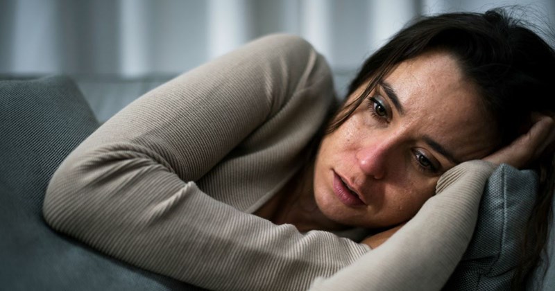 An exhausted daycare business owner rests on the couch after spending 12 hours a day caring for children and cleaning her house so it is suitable for childcare.